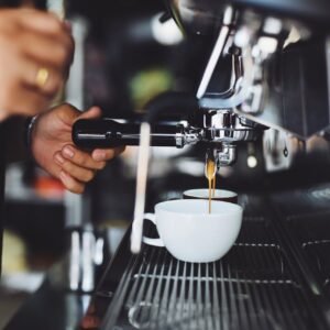 Close-up of a barista making espresso with a coffee machine in a café.